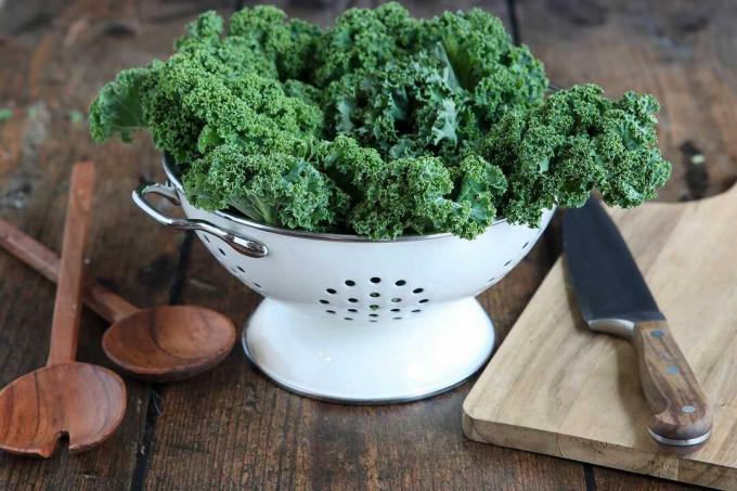 Kale in colander with cutting board and knife