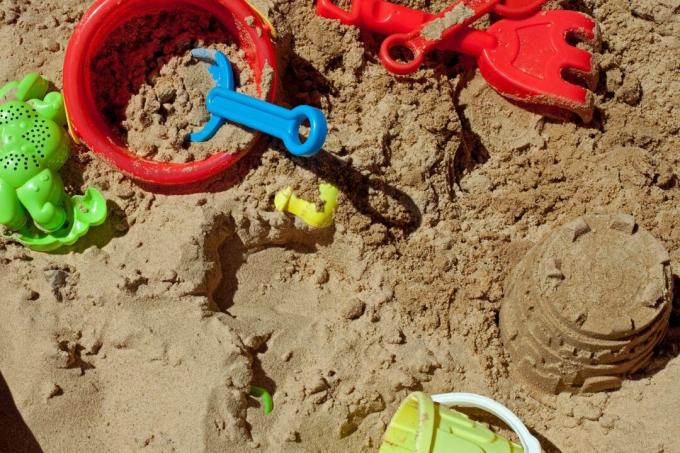 Moldes, baldes e pequenas estruturas de areia na caixa de areia
