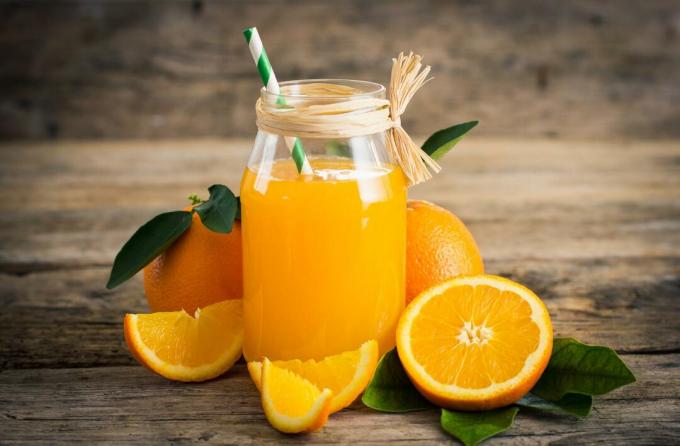 Rodajas de naranjas y jugo en mesa