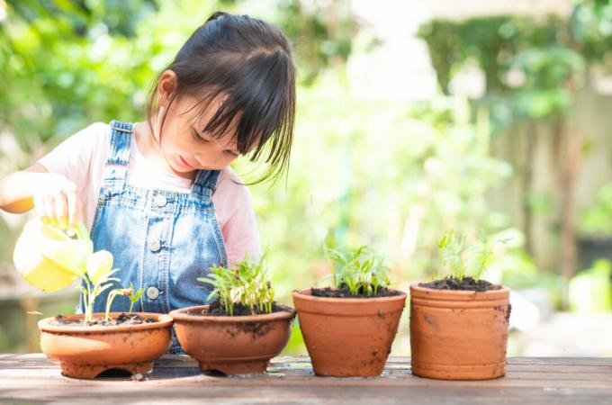 Dijete s loncima za cvijeće zalijevanje