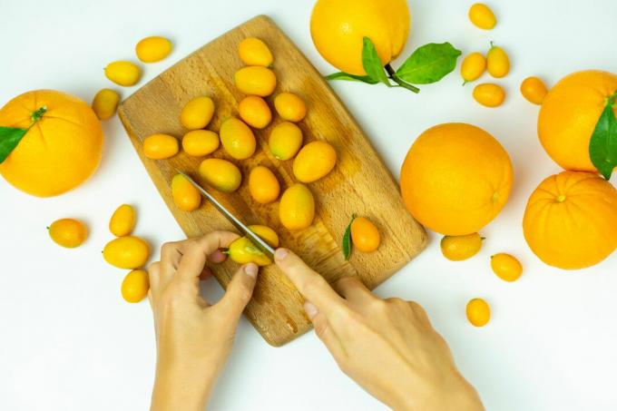 Kumquats skæres med en kniv