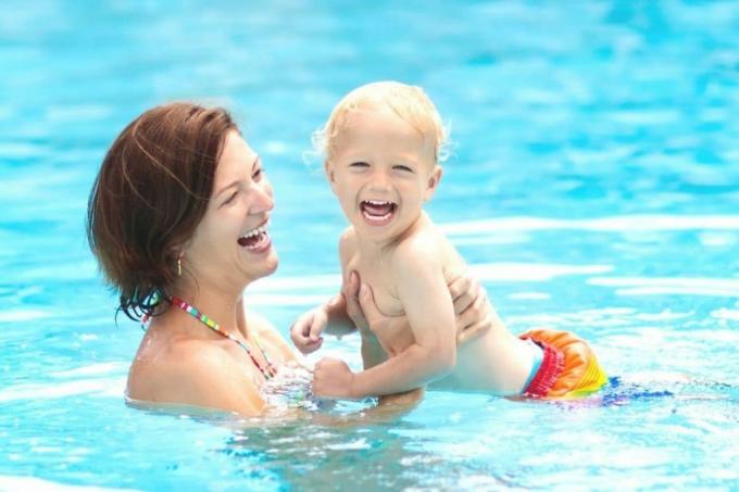 Mother splashes with child in the pool