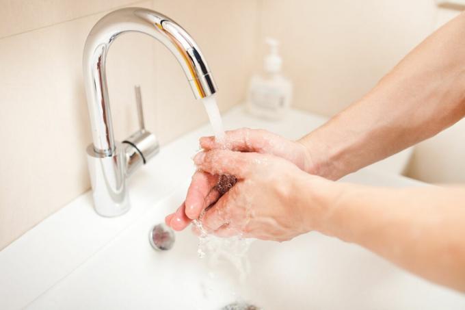 Händerna tvättas i handfatet