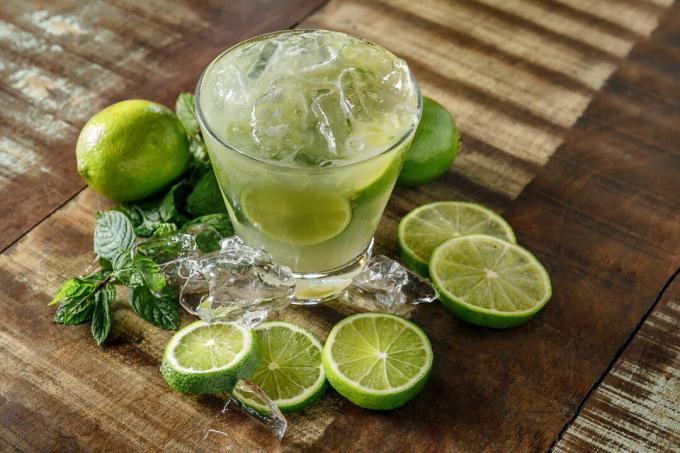 Du vrai citron vert autour d'un verre de capirinha